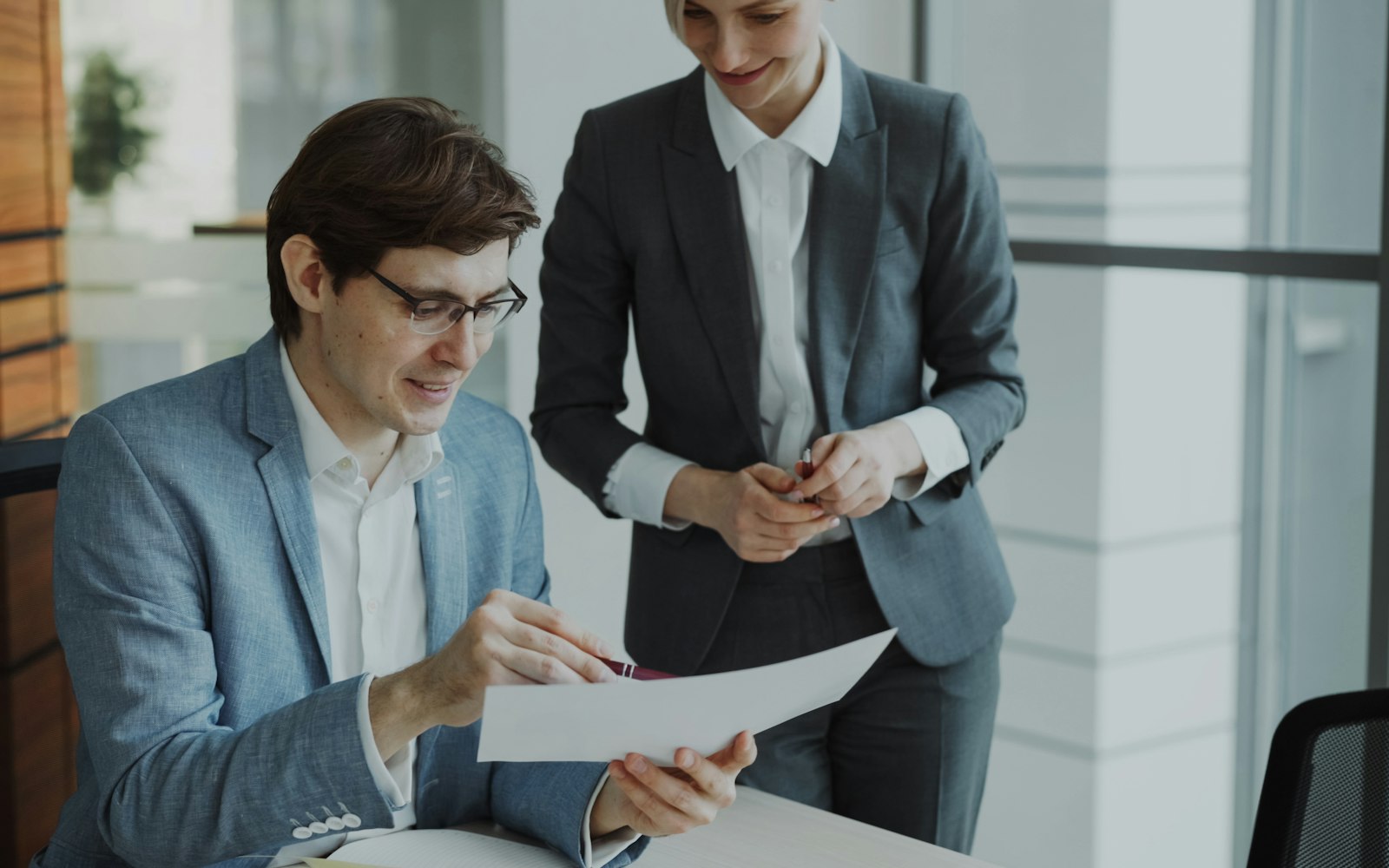 Un titolare consegna un documento a un collaboratore in ufficio